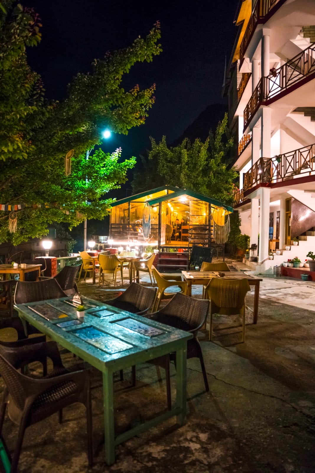 The cafe hut lit up at night with fairy lights and a guest inside