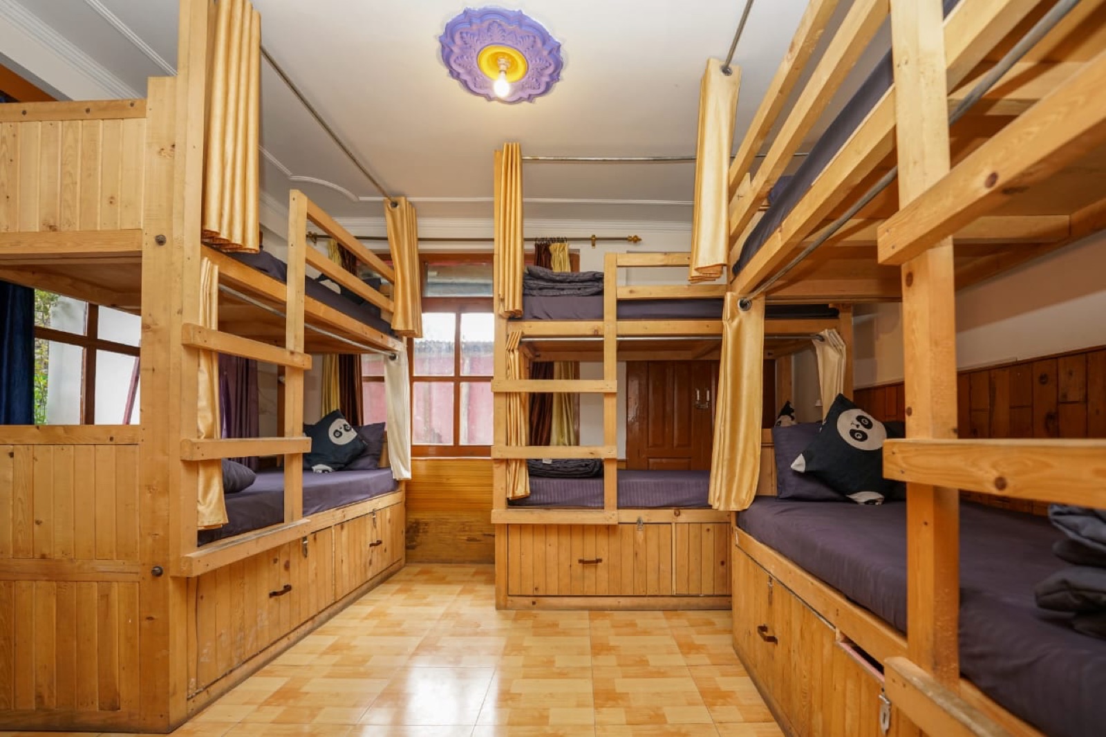 6-bed dorm, wide view, beds made with curtained bunks