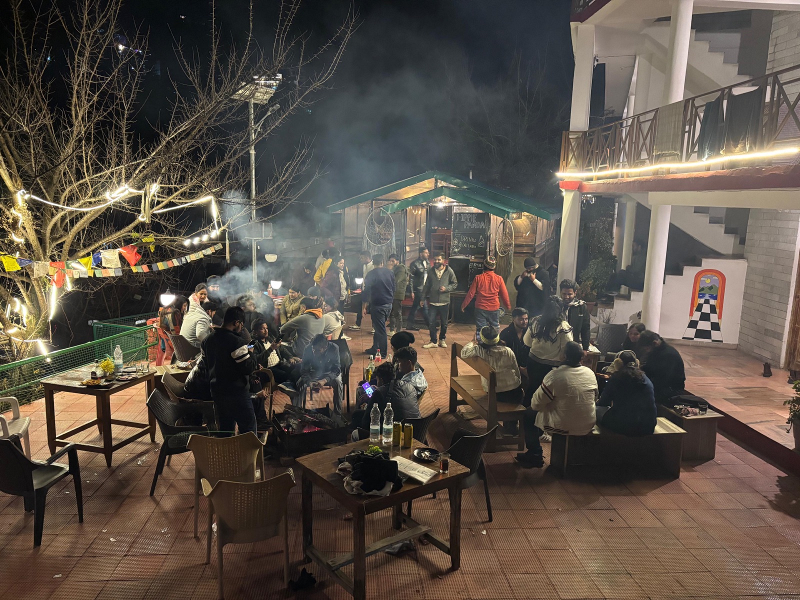 Guests gathered around the courtyard bonfire at night