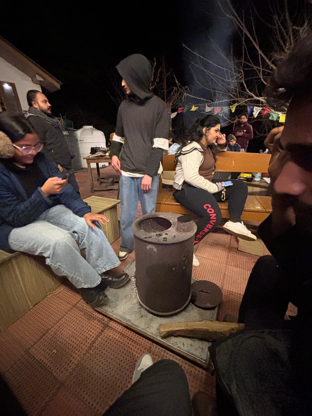 Close-up of guests gathered around the fire at night