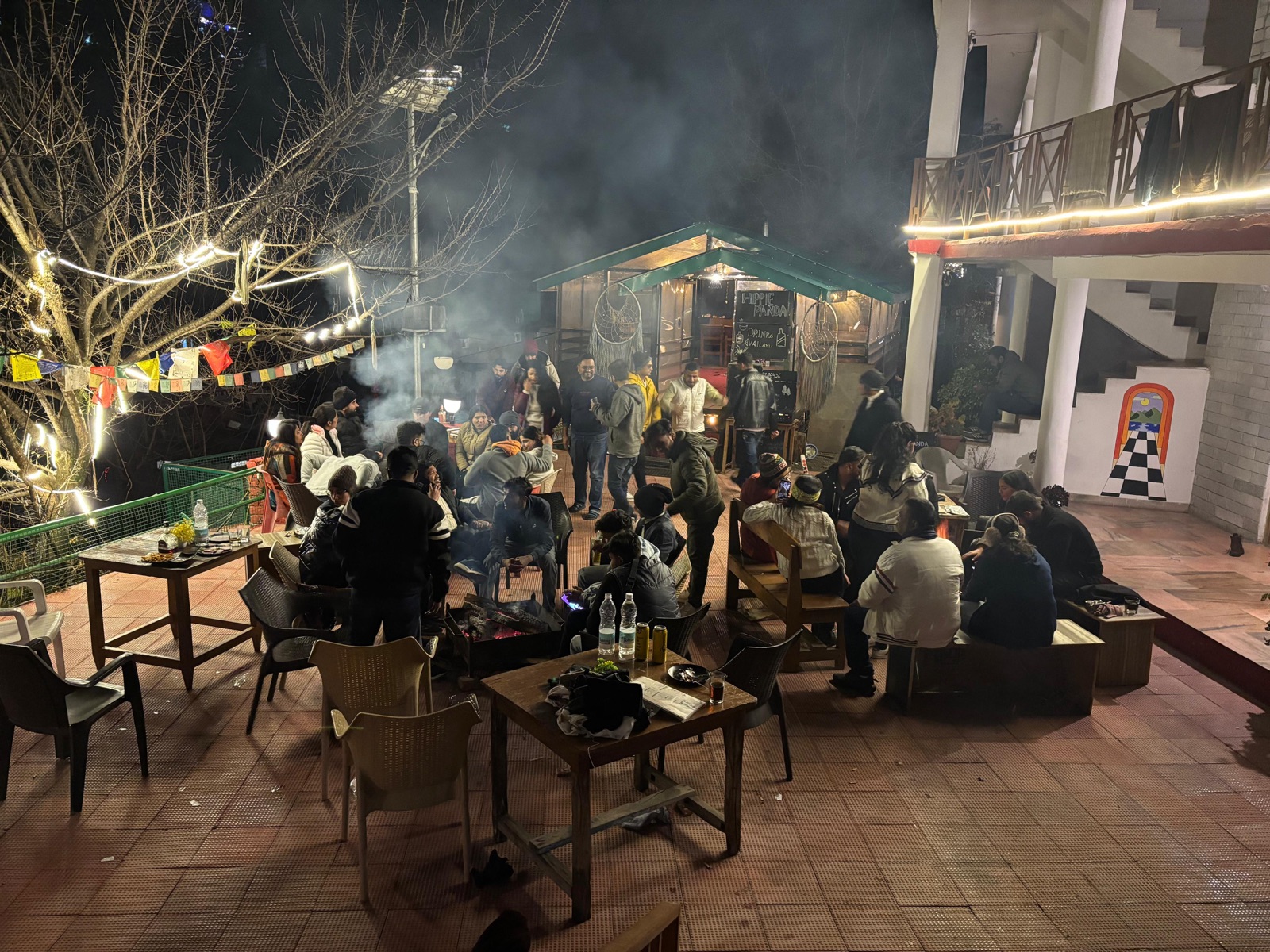 The courtyard bonfire at night, a large group gathered around it