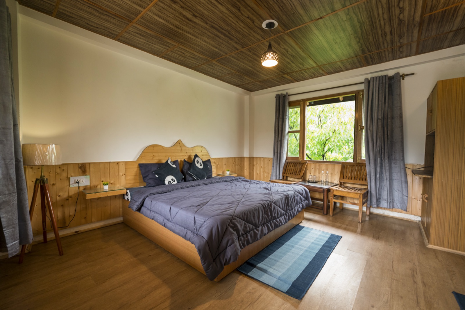 Private double room, bed made, daylight through the windows